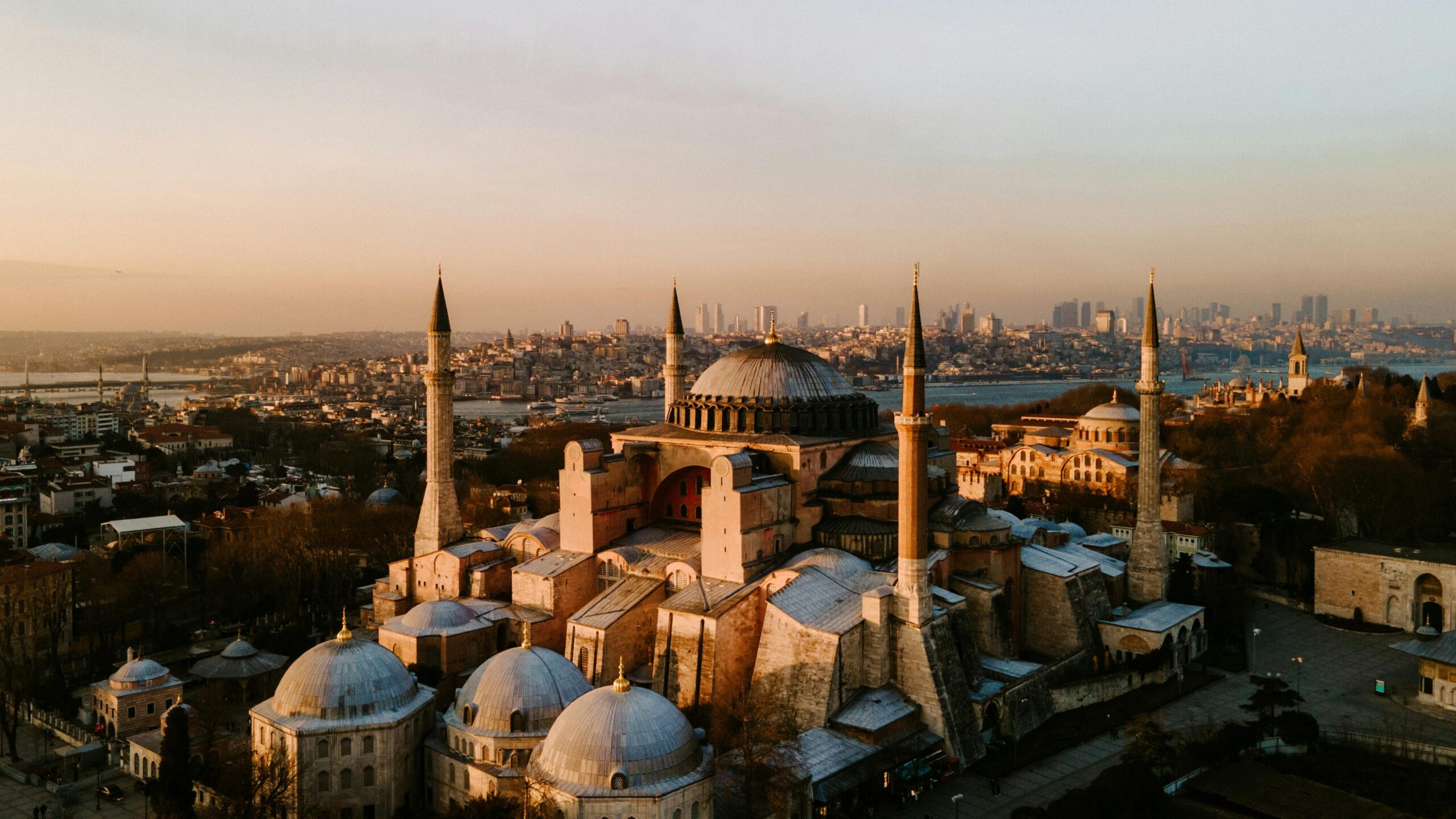 Majestic aerial view of Hagia Sophia and Istanbul skyline with a warm sunset glow.
