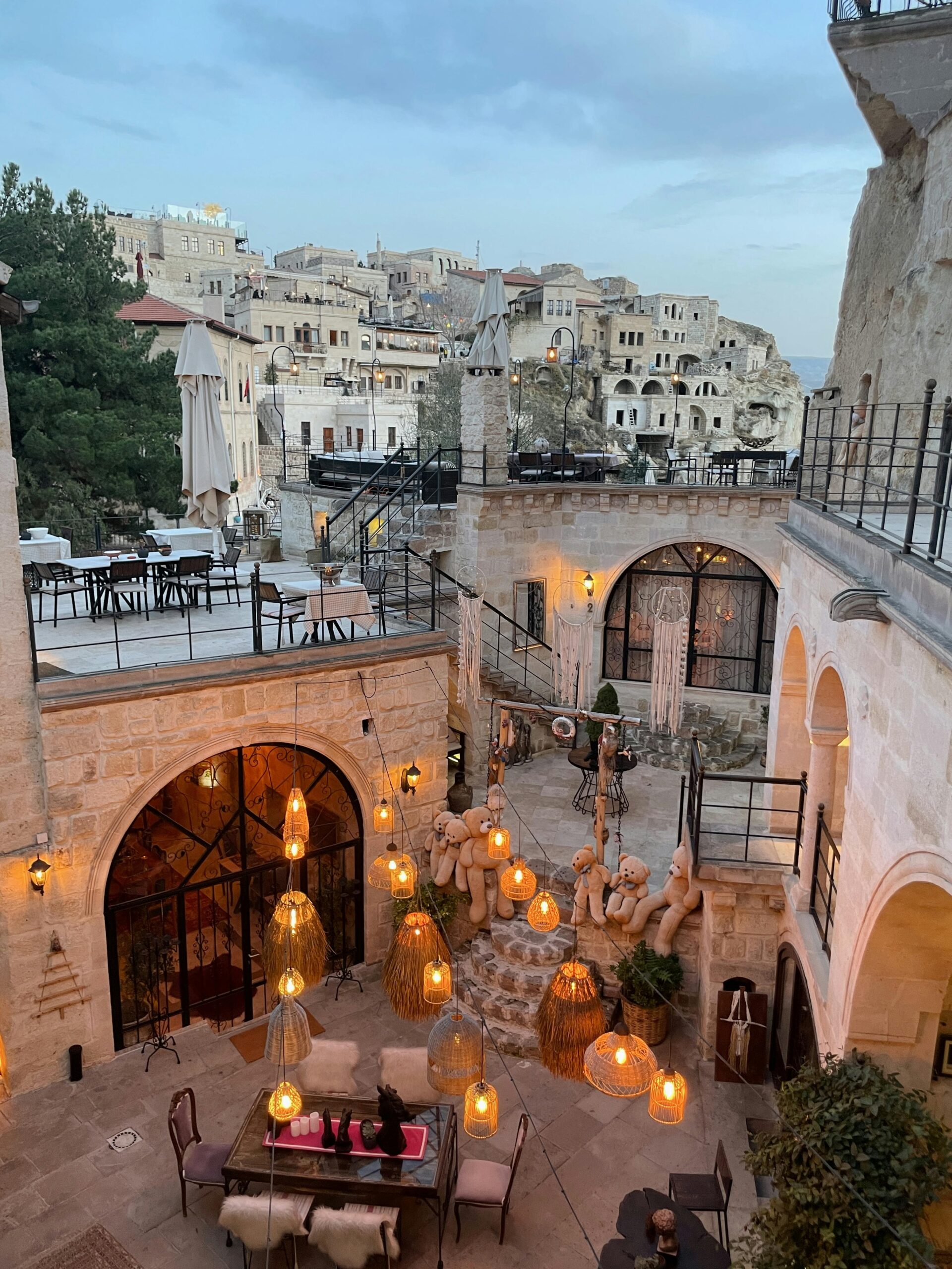 Charming Cappadocia courtyard with ambient lighting at dusk, showcasing unique architecture.